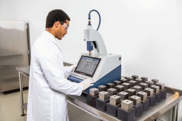 A precision Gauge Block Comparator instrument measuring gauge blocks for length calibration in a metrology laboratory.